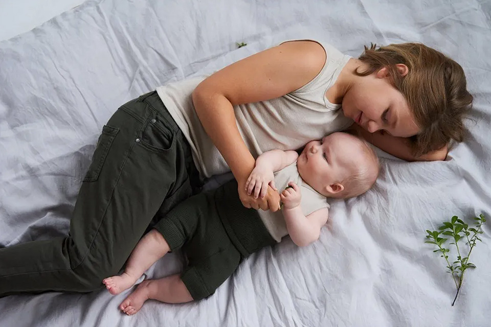 Mother sleeping with baby image